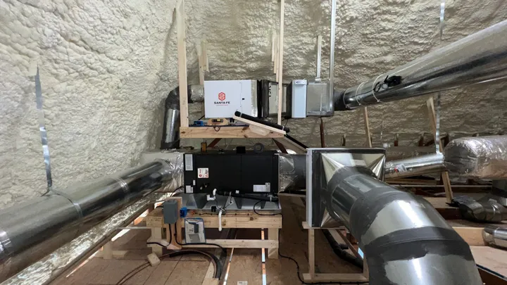 HVAC air handler and insulated ductwork installed inside a spray-foam-encapsulated attic