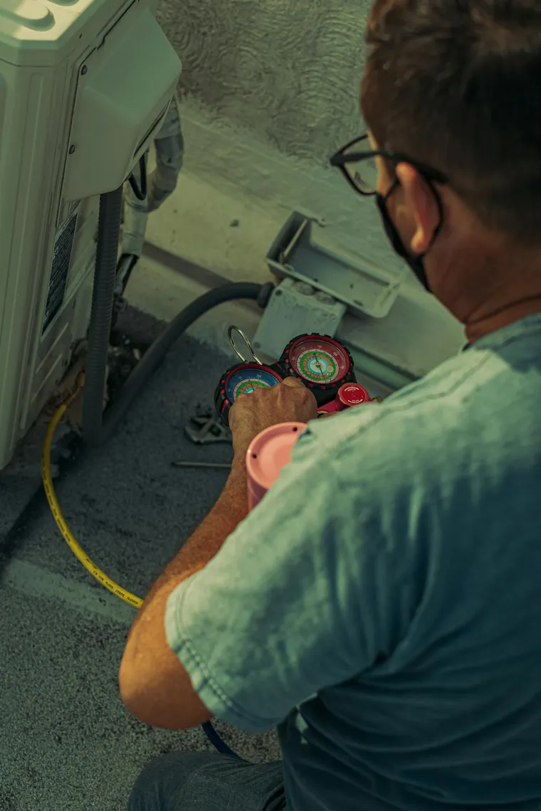 HVAC technician checking system pressure gauges